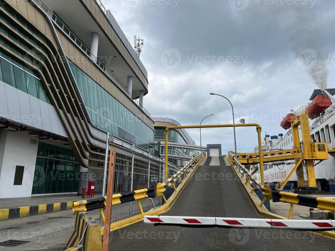 Yellow ship bridge with black yellow lines and car parking space inside the ship photo