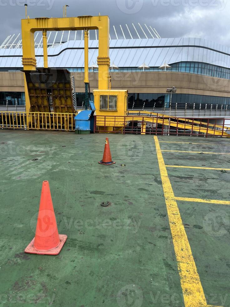 Road symbol cone in rest area parking lot and ship with yellow guide lines for cars photo