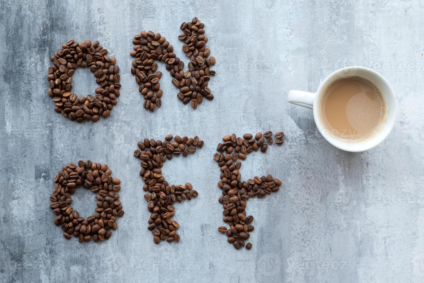 cup of coffee as a switch between ON and OFF beans, gray stone background, morning or waking up concept photo