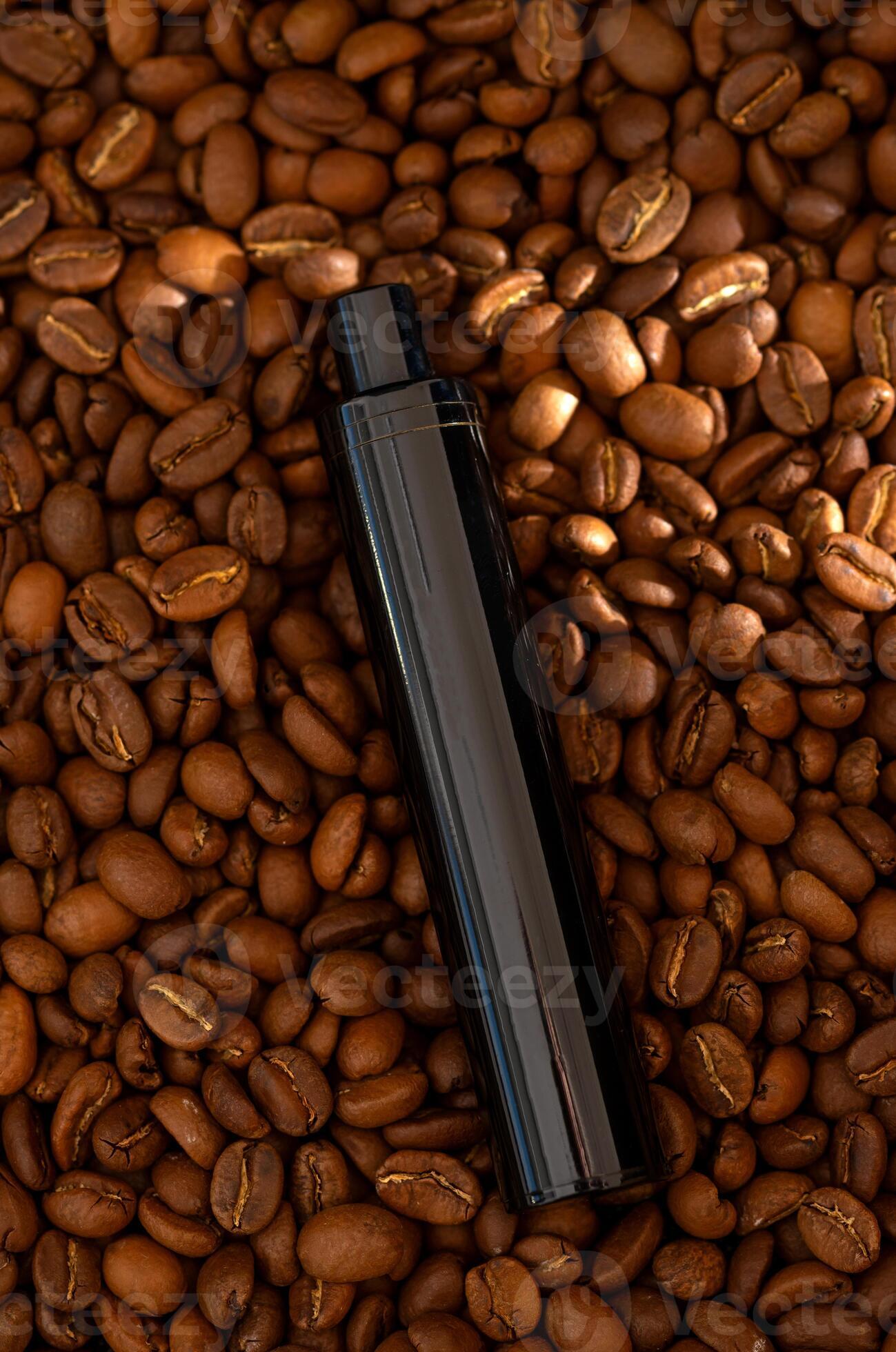 Coffee beans background and Ecigarette. Coffee flavored vape juice