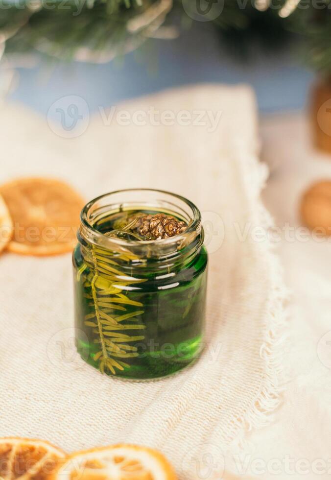 Green honey with pine needles in a glass jar. Glass jar with honey on a christmas atmosphere background. National Recipes. photo