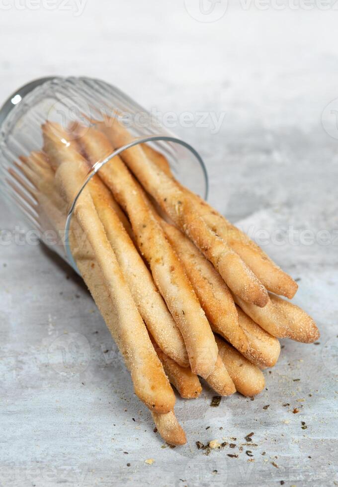 Grissini with herbs on a gray concrete background photo