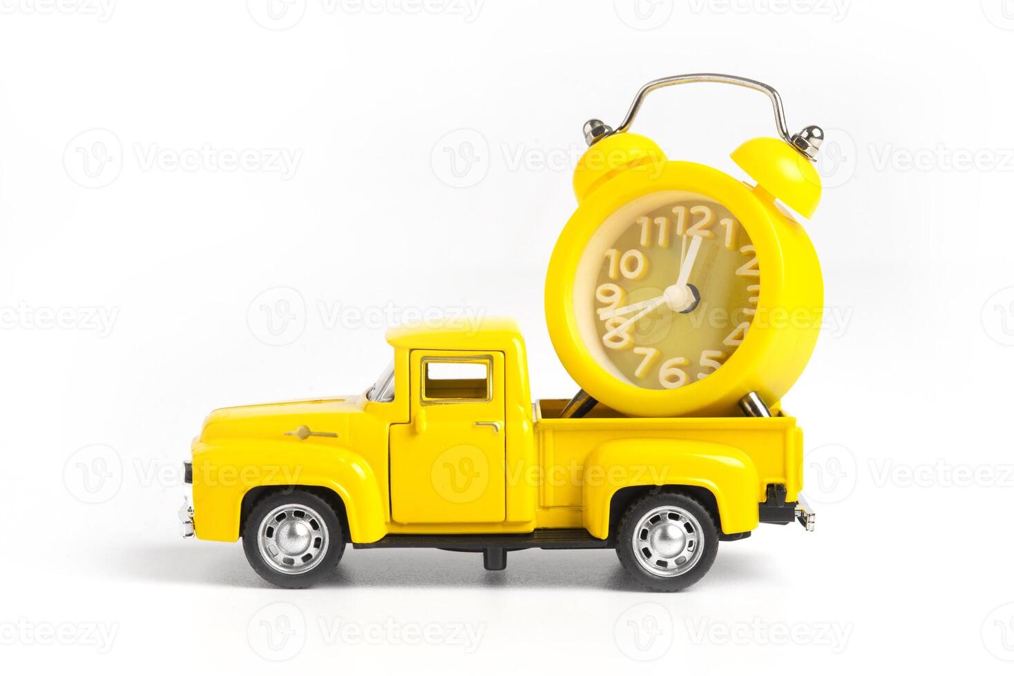 A yellow alarm clock in a toy truck. White background with copy space for text. Deadline and the concept of timeliness photo