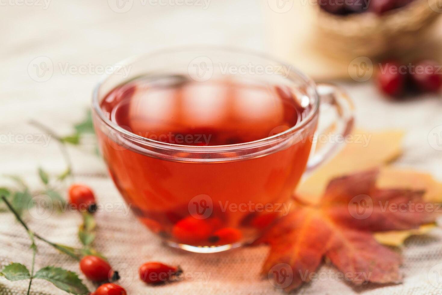 A cup of rose hip tea with fresh berries in a glass cup. Vintage background, selective focus photo