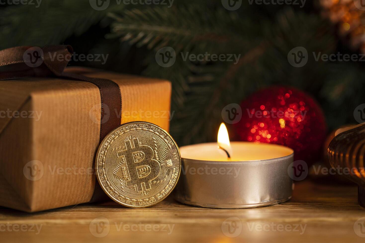 Gold coin bitcoin stands near the christmas decorations on the table with gift box, a spruce branch and candle. Beautiful Christmas, new year background with bitcoin. Digital currency. photo