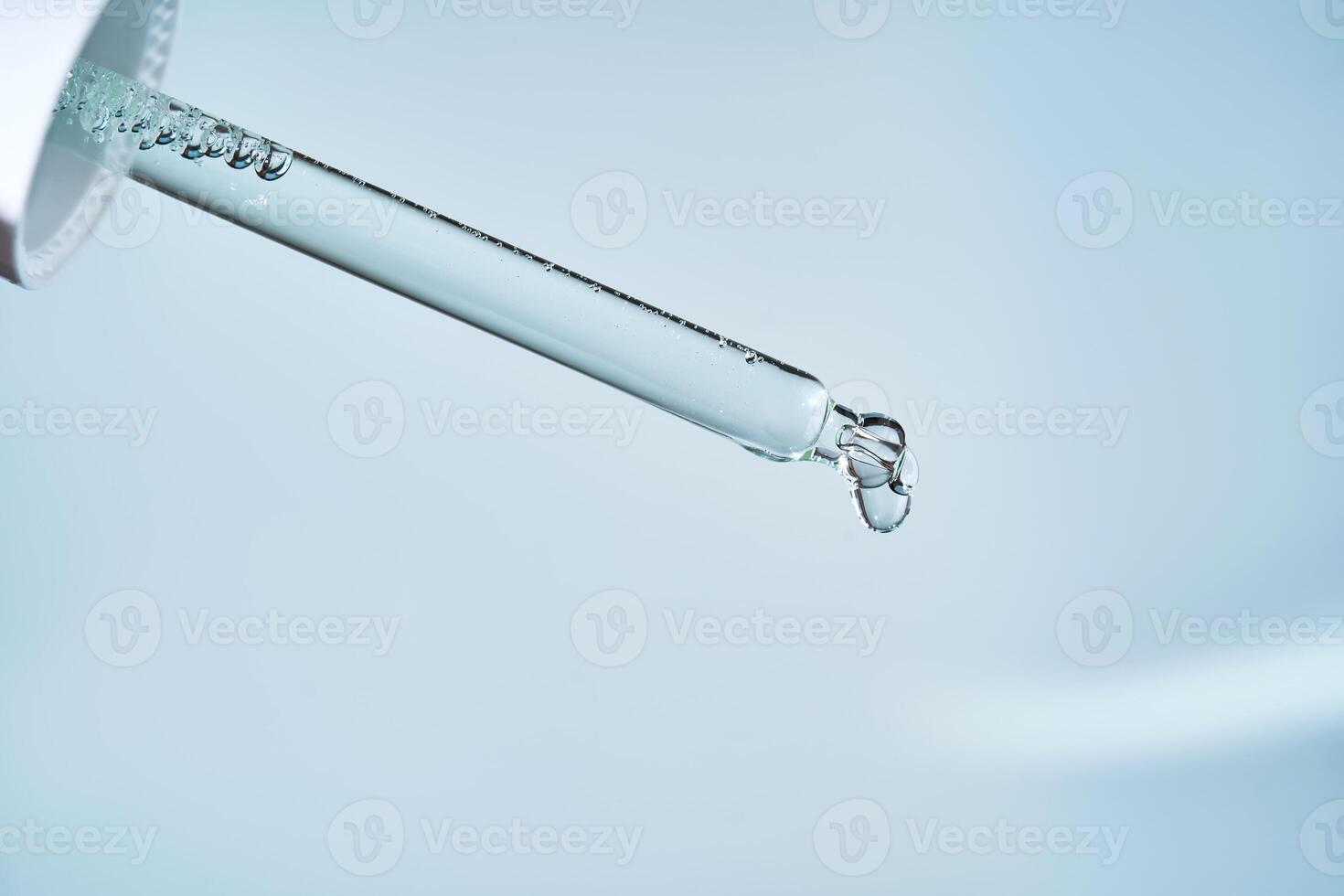 Pipette with serum on a blue background. photo