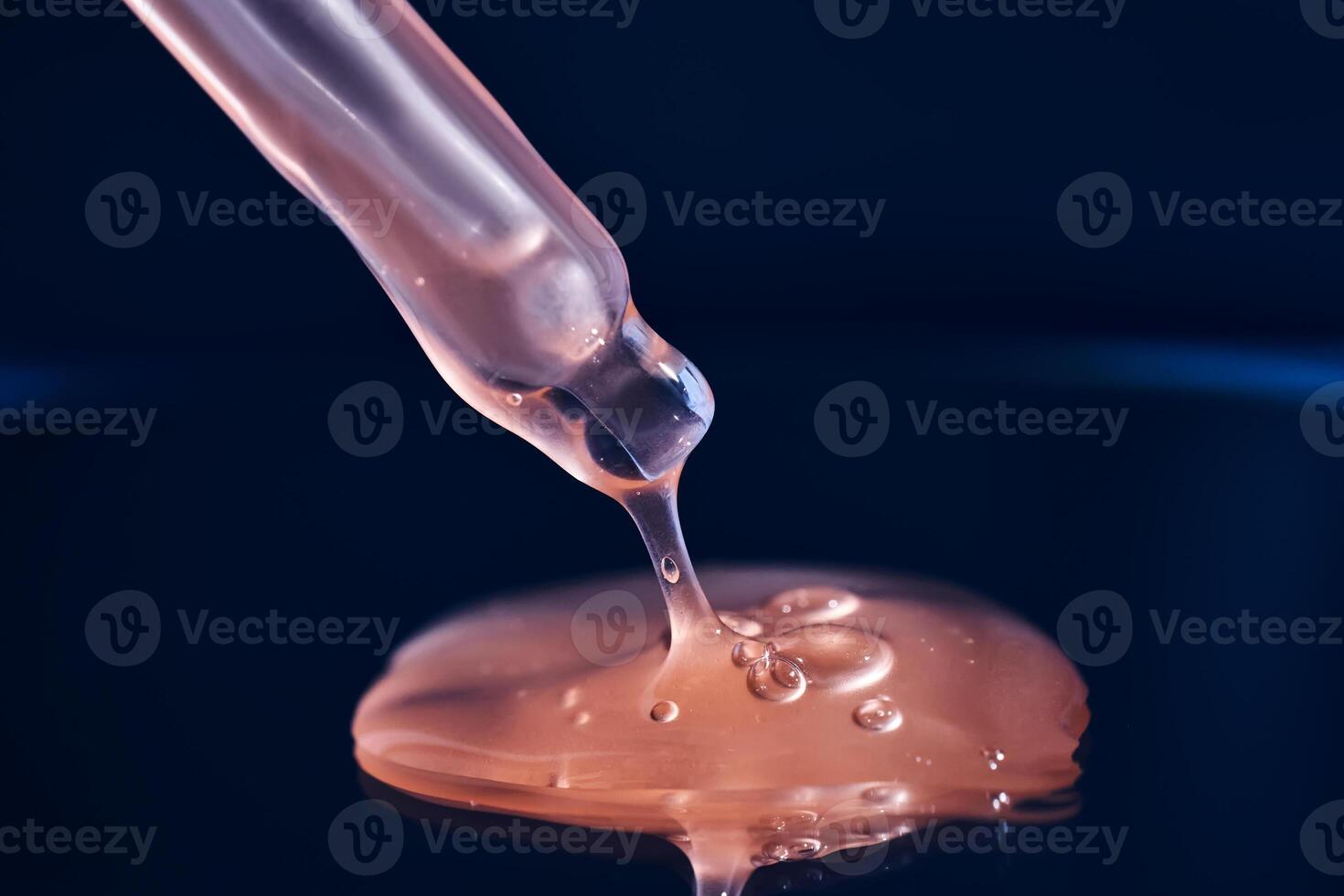 Bottle with pink serum on a blue background. photo