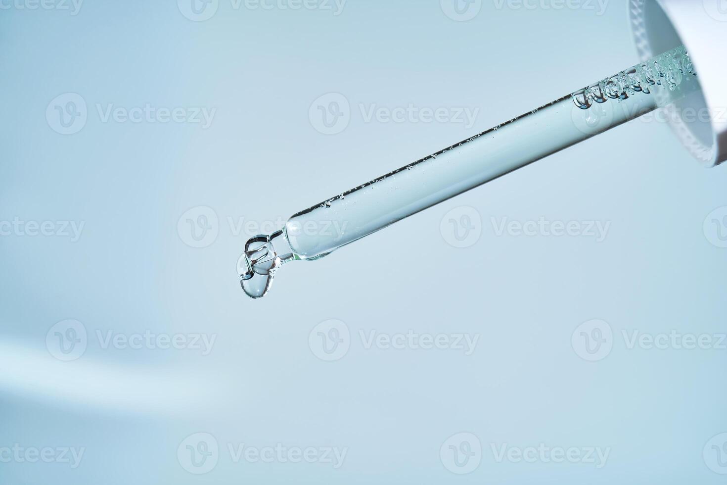 Pipette with serum on a blue background. photo