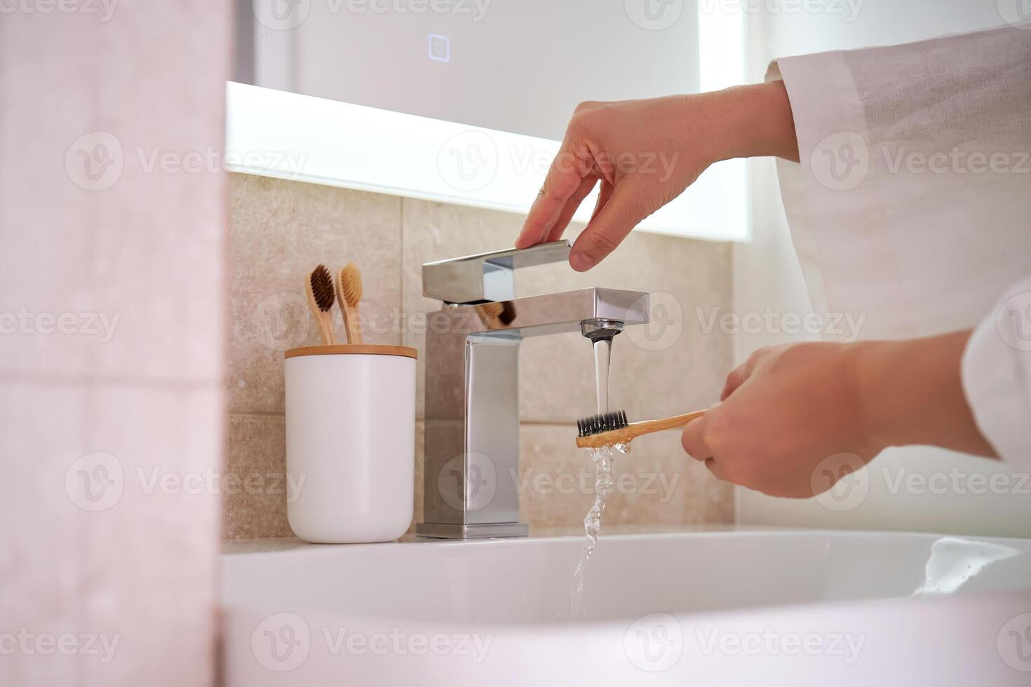 Women's hands under running water in the bathroom. Morning routine. photo