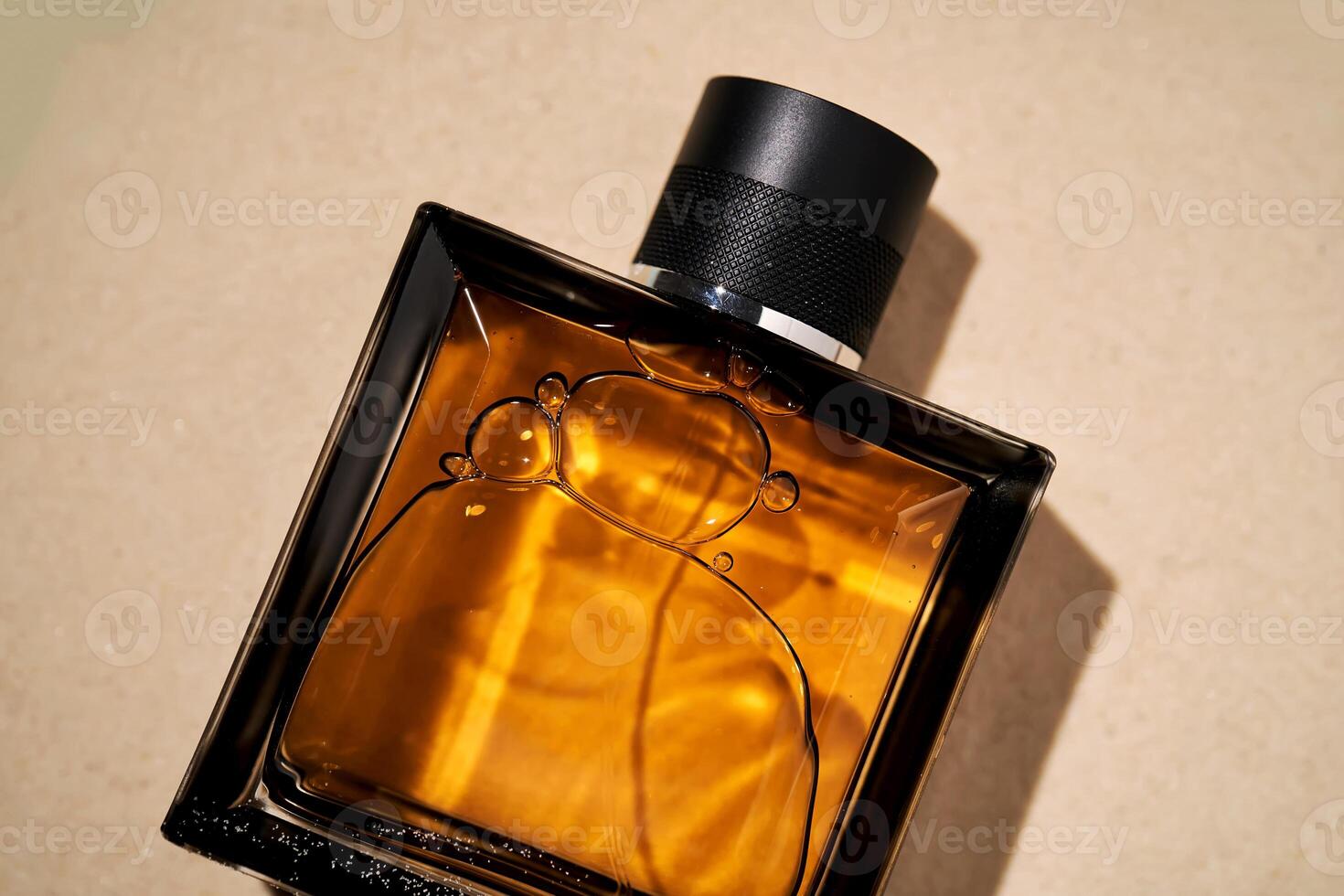 A bottle of perfume on a background of sand. photo