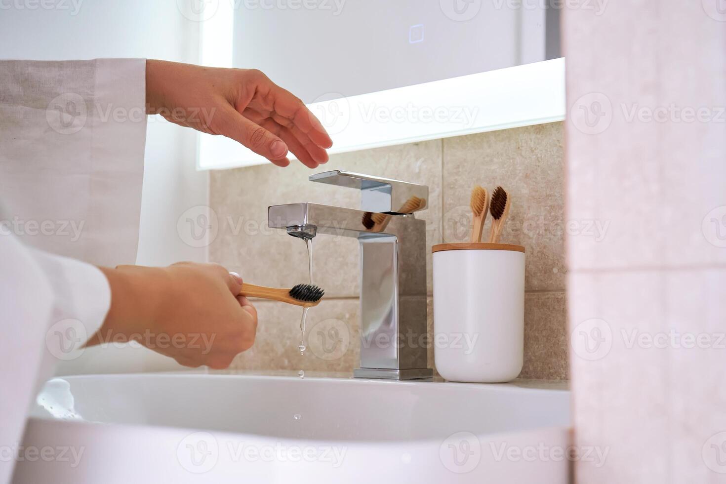 Women's hands under running water in the bathroom. Morning routine. photo