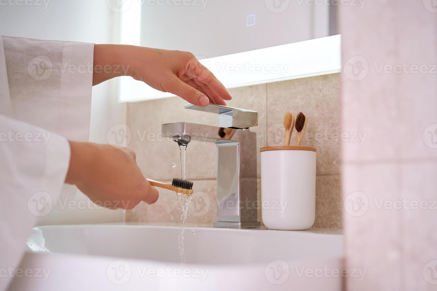 Women's hands under running water in the bathroom. Morning routine. photo