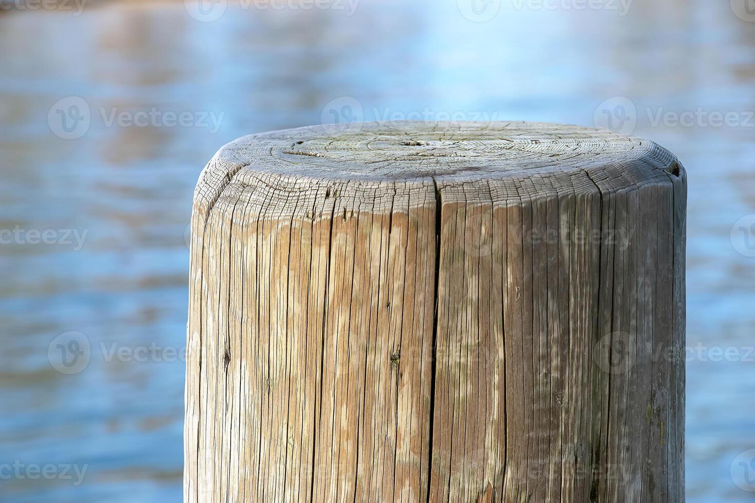 A pier made of wooden piles for mooring boats and maintaining the stability of the pier against the backdrop of water Lake Traunsee in Austria. photo