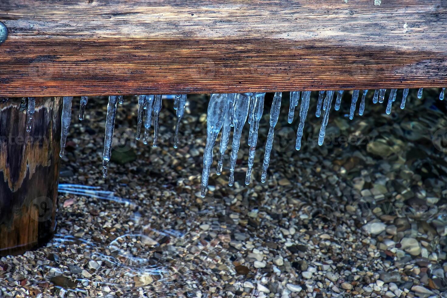 Icicles between the bridge and the surface of Lake Traunsee in Austria. photo