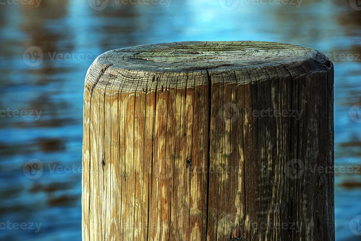 A pier made of wooden piles for mooring boats and maintaining the stability of the pier against the backdrop of water Lake Traunsee in Austria. photo