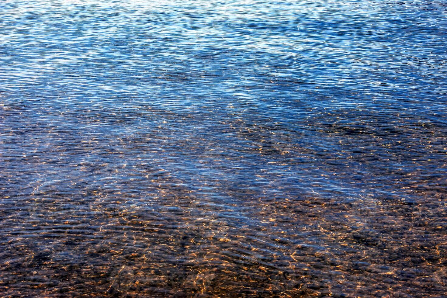 Background of the water of Lake Traunsee in the coastal area. Colorful texture of stones under water. photo