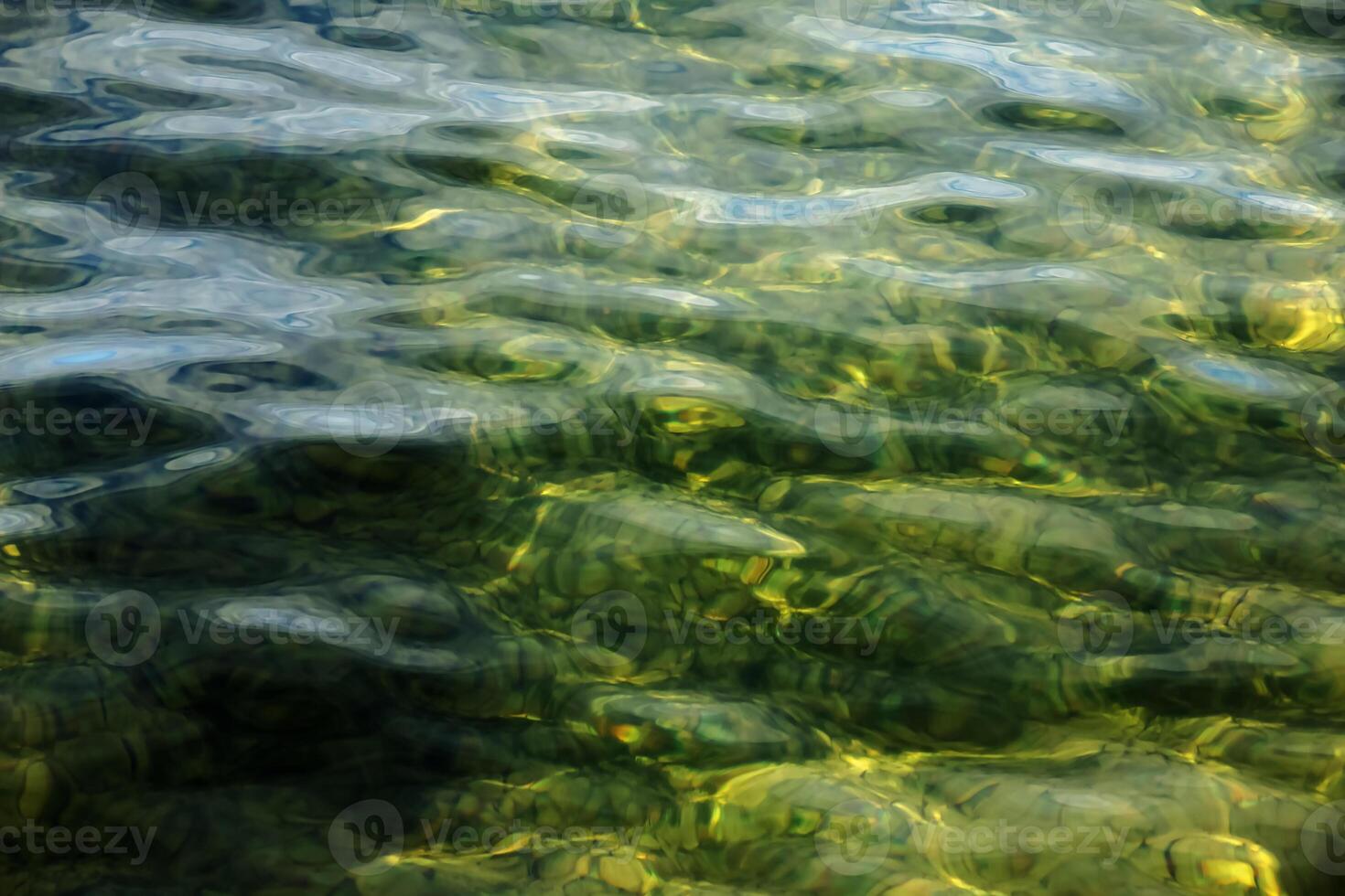 Background of the water of Lake Traunsee in the coastal area. Colorful texture of stones under water. photo