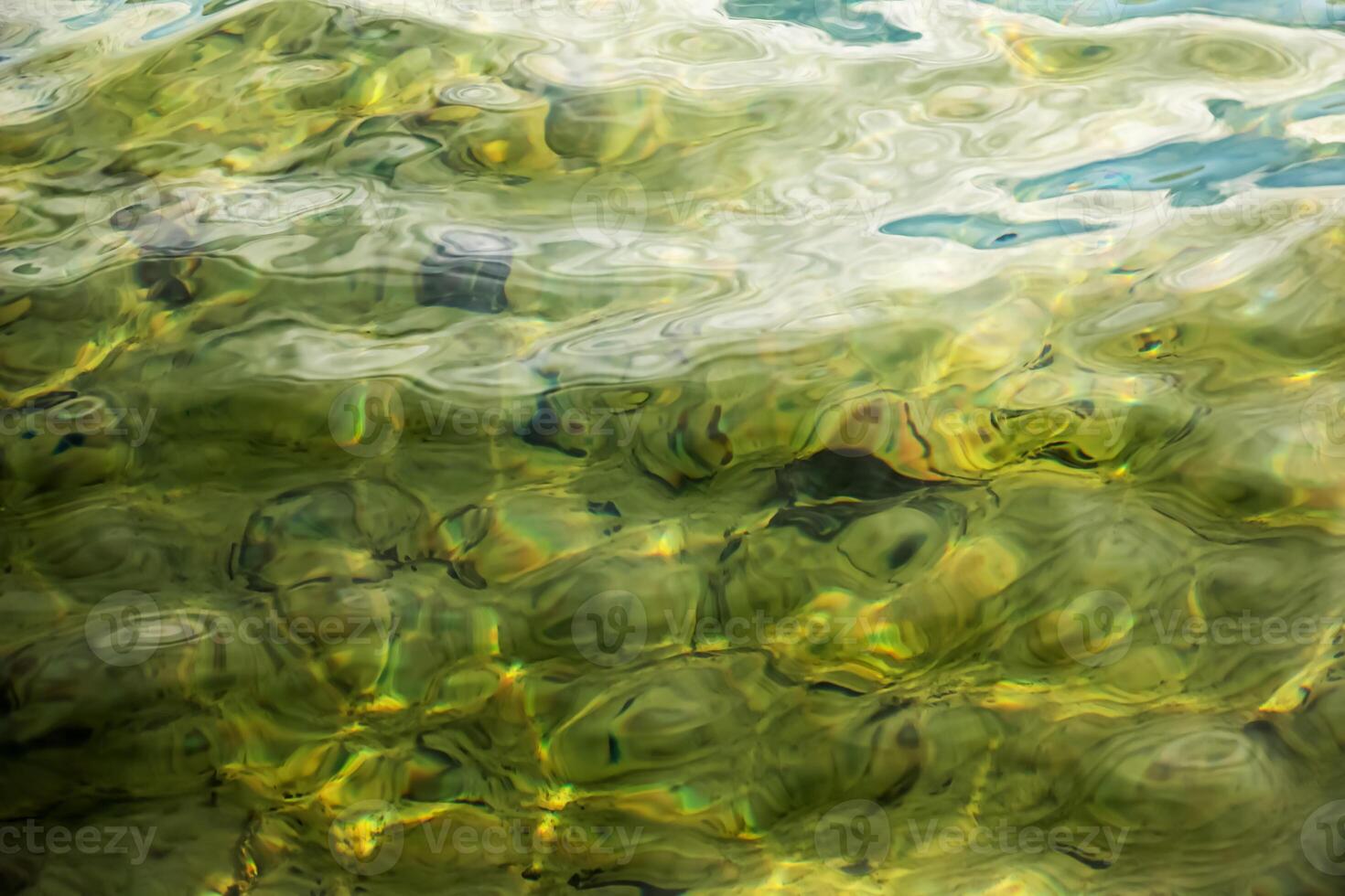 antecedentes de el agua de lago traunsee en el costero área. vistoso textura de piedras debajo agua. foto