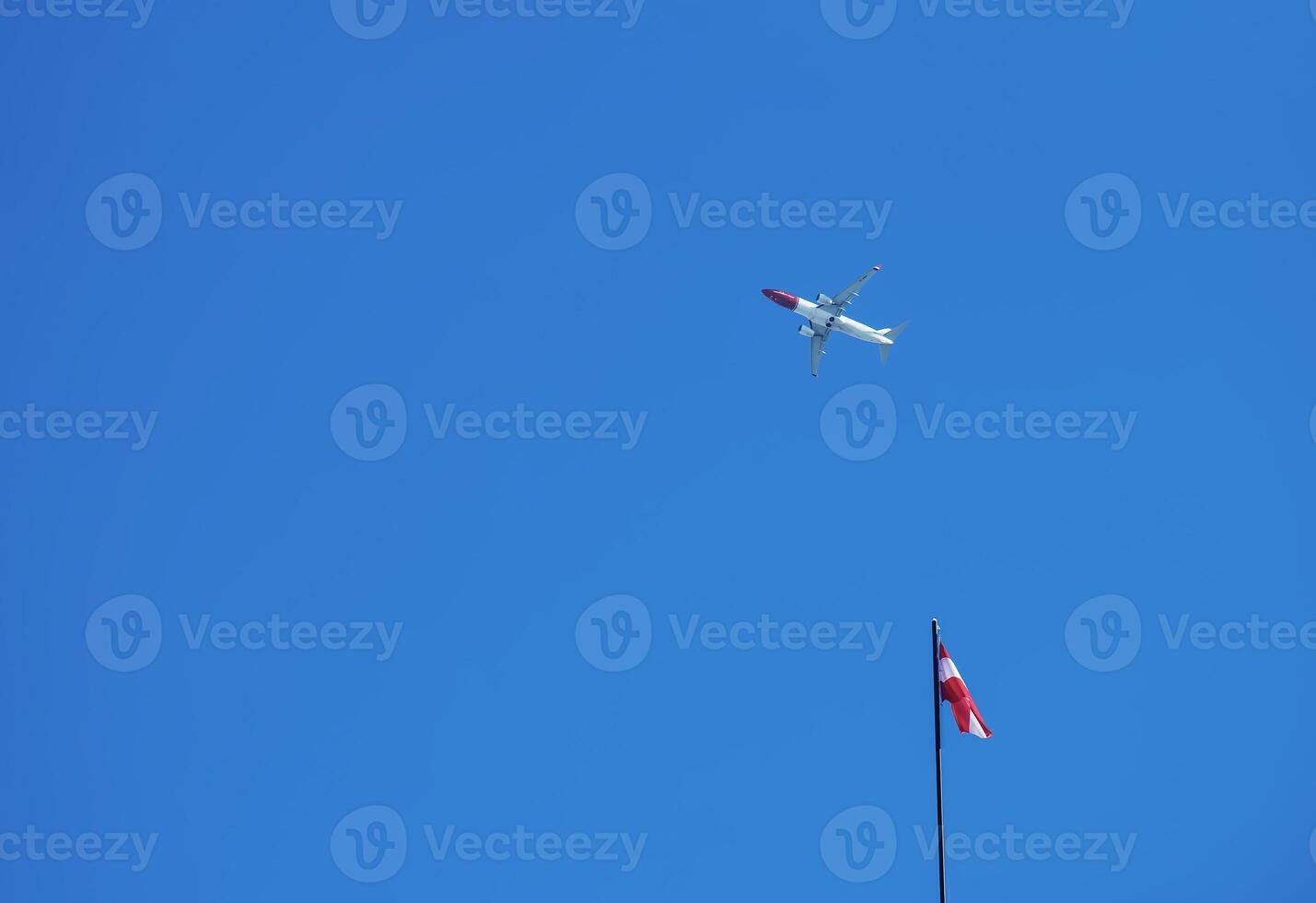 Austrian flag and airplane against the blue sky on a sunny day. photo