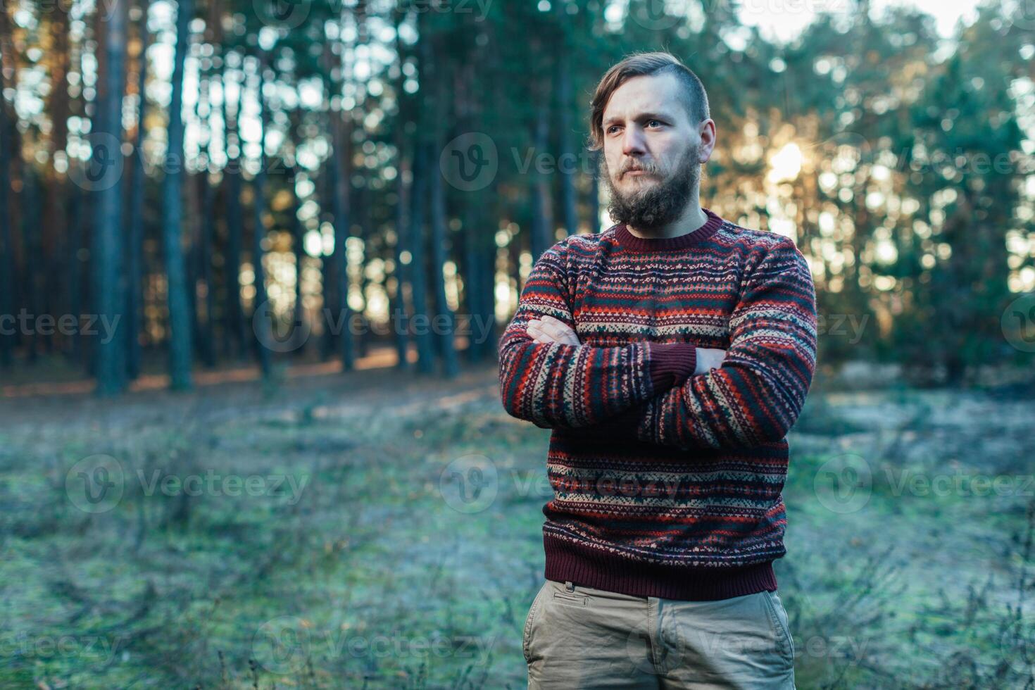 Portrait brutal bearded hipster man in the forest photo