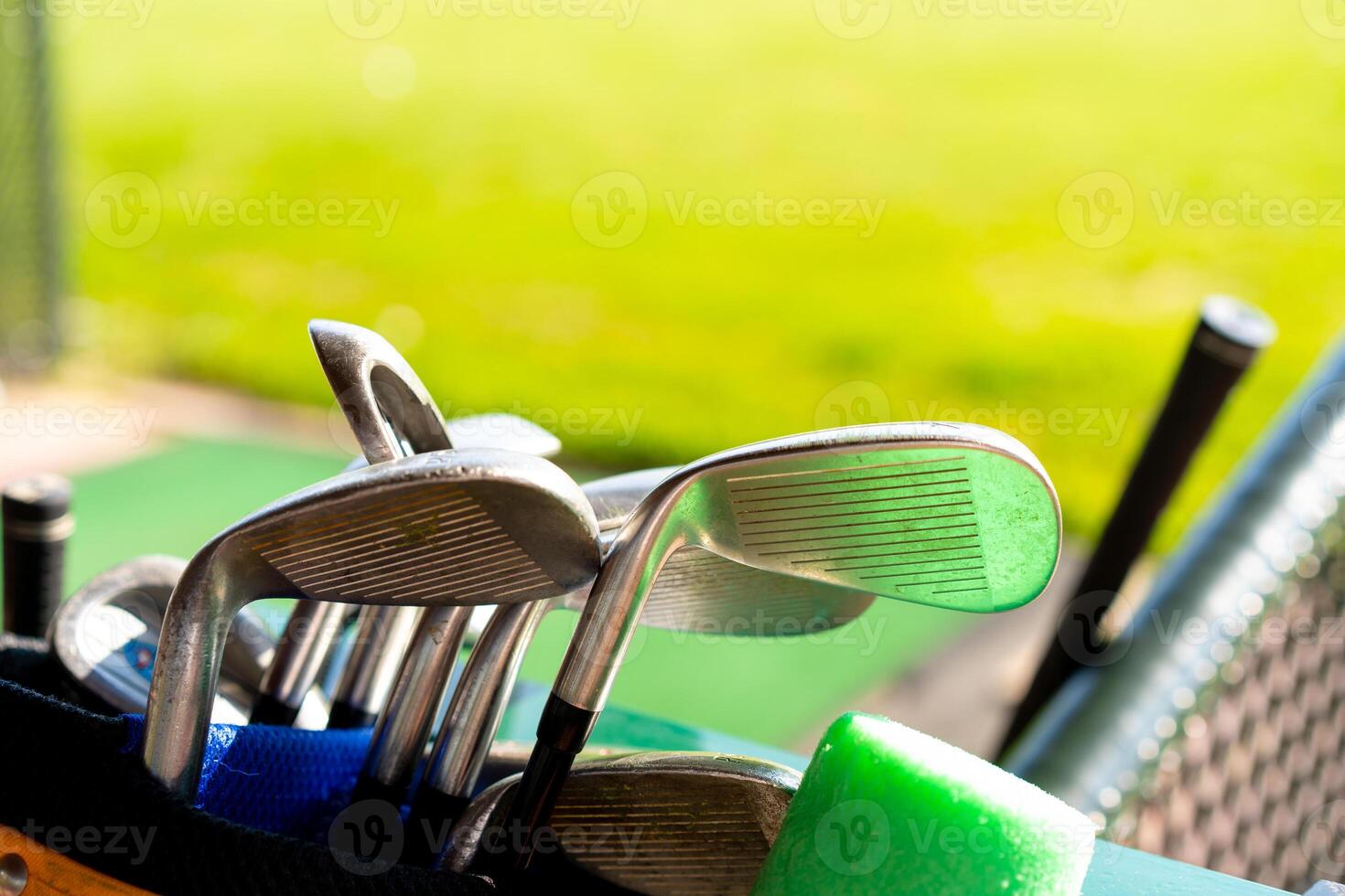 Golf clubs drivers over green field background photo