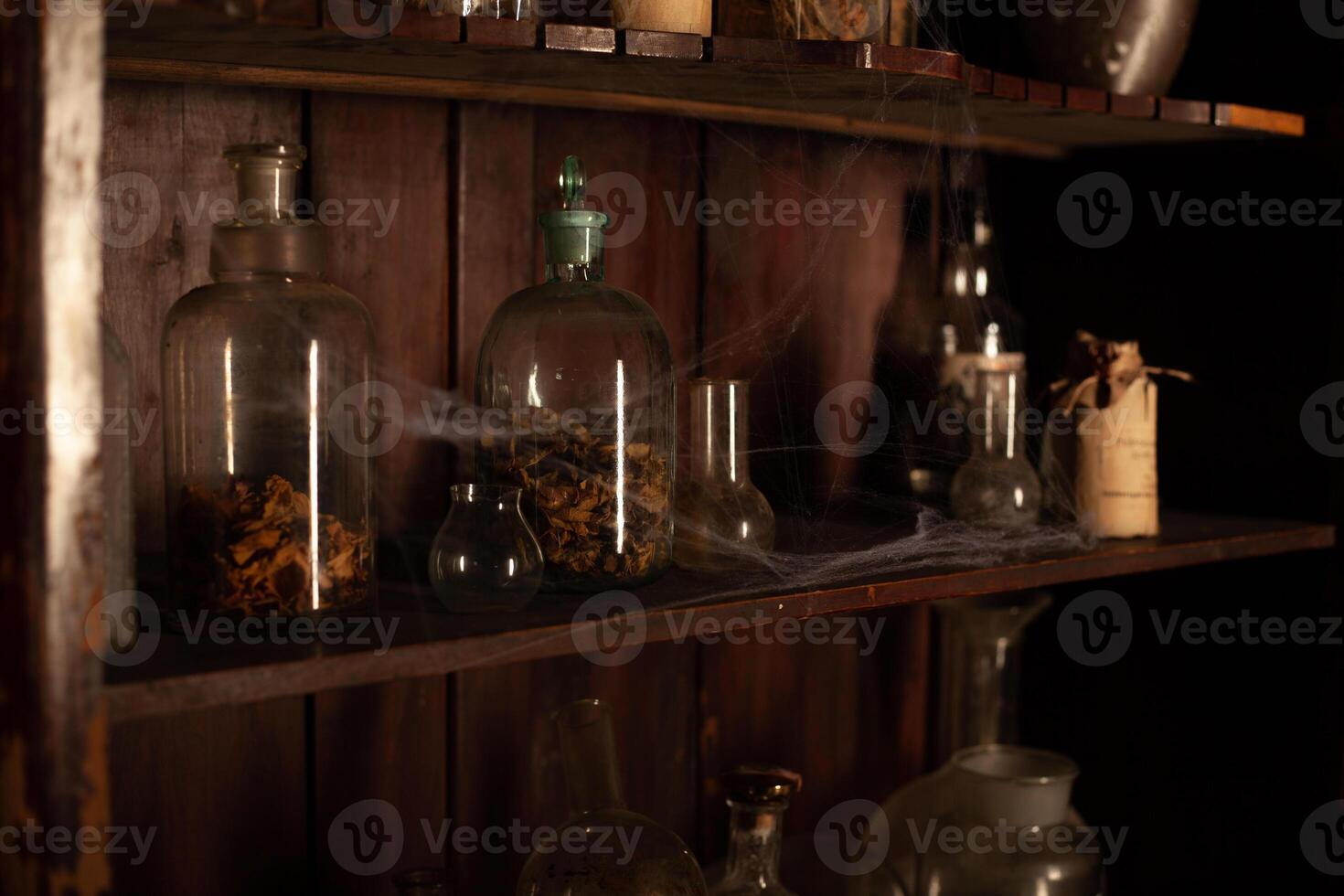 Halloween background Shelves with alchemy tools Skull spiderweb bottle with poison candles photo
