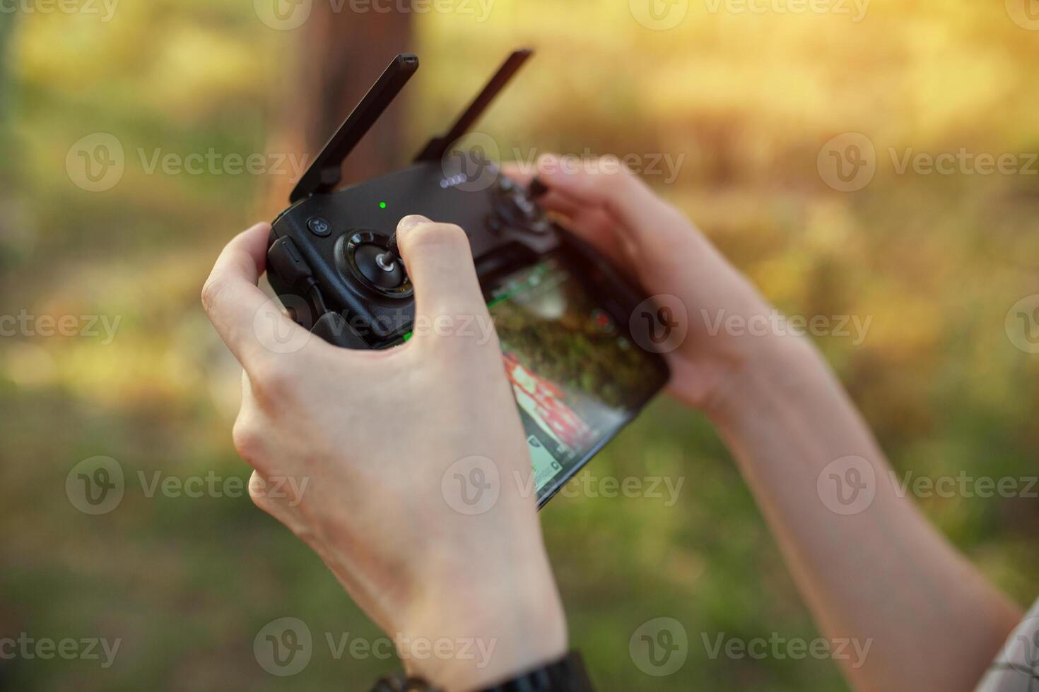 remoto controlar para cuadricóptero, de cerca. transmisor para controlador Moviente dispositivo en masculino manos, borroso naturaleza antecedentes. electrónica, pasatiempo, aeromodelismo concepto foto