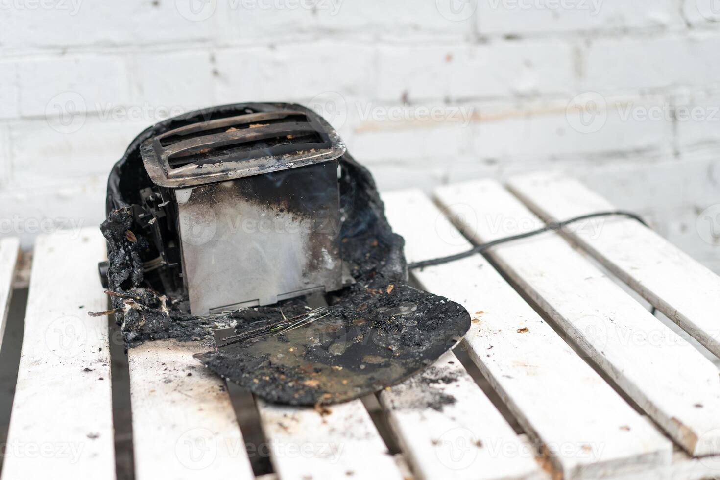 Burning toaster. Toaster with two slices of toast caught on fire over white background photo