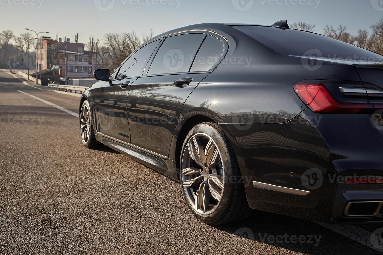 Black city car driving on the road, modern car background photo