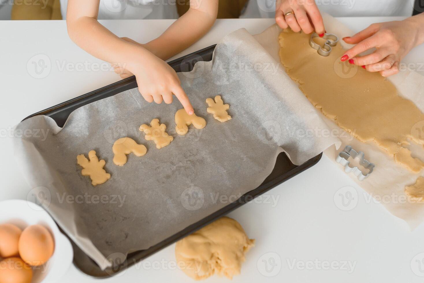 Young mother and son in kitchen making cookies. photo