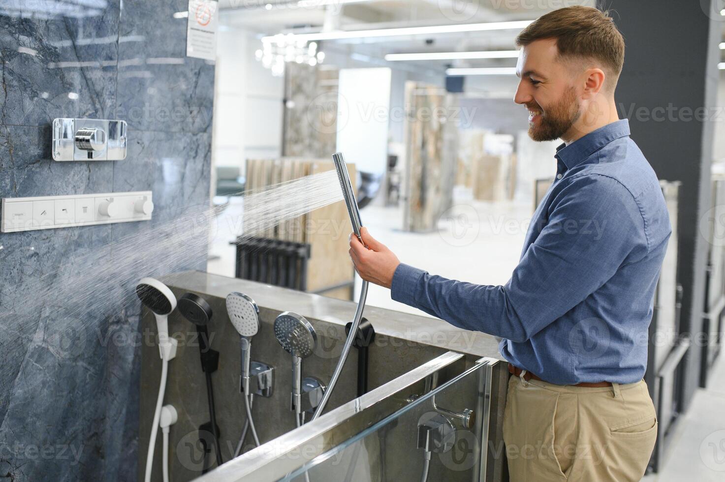 Selects a shower faucet. Man chooses a products in a sanitary ware store photo