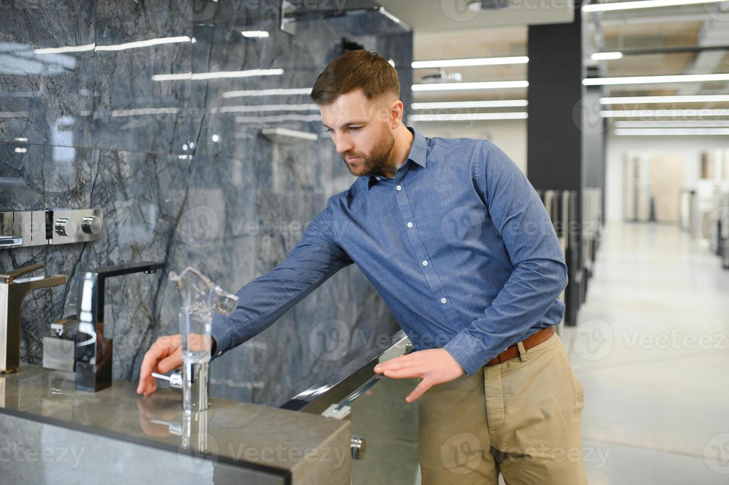 Selects a shower faucet. Man chooses a products in a sanitary ware store photo