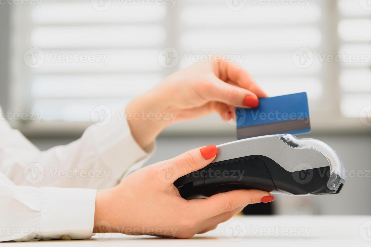 cerca arriba de mano utilizando crédito tarjeta deslizar máquina a pagar. crédito tarjeta pago mediante un compras Terminal. crédito tarjeta pago para nuevo ropa colección foto