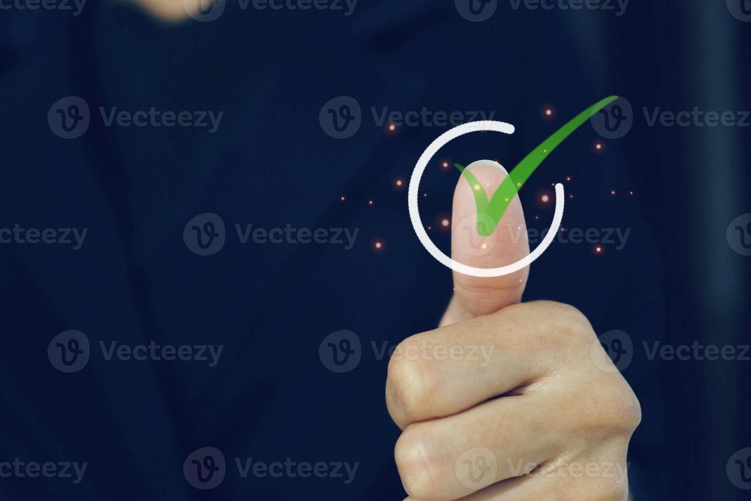 Businessman gives thumbs up with virtual sign or check mark for approval and guarantee concept. photo