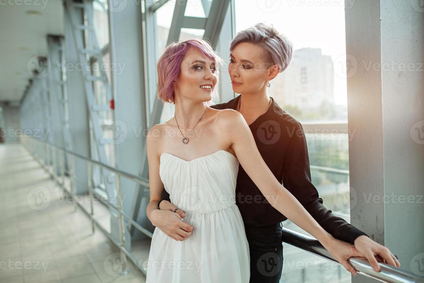 people, homosexuality, same-sex marriage, travel and gay love concept - close up of happy women couple hugging over metall bridge. Two girlfriend walking. photo