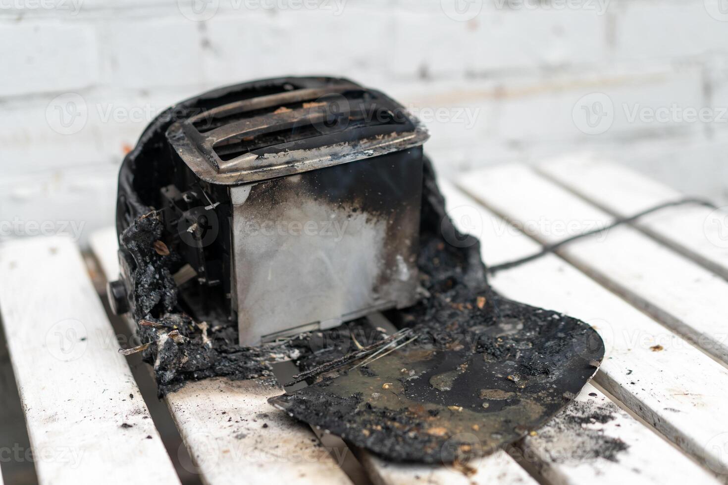 Burning toaster. Toaster with two slices of toast caught on fire over white background photo