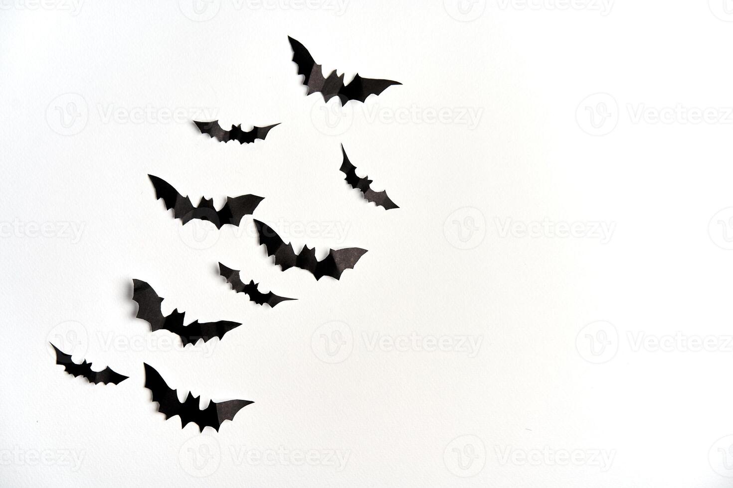 Halloween decoration concept black paper bats white cardboard background photo