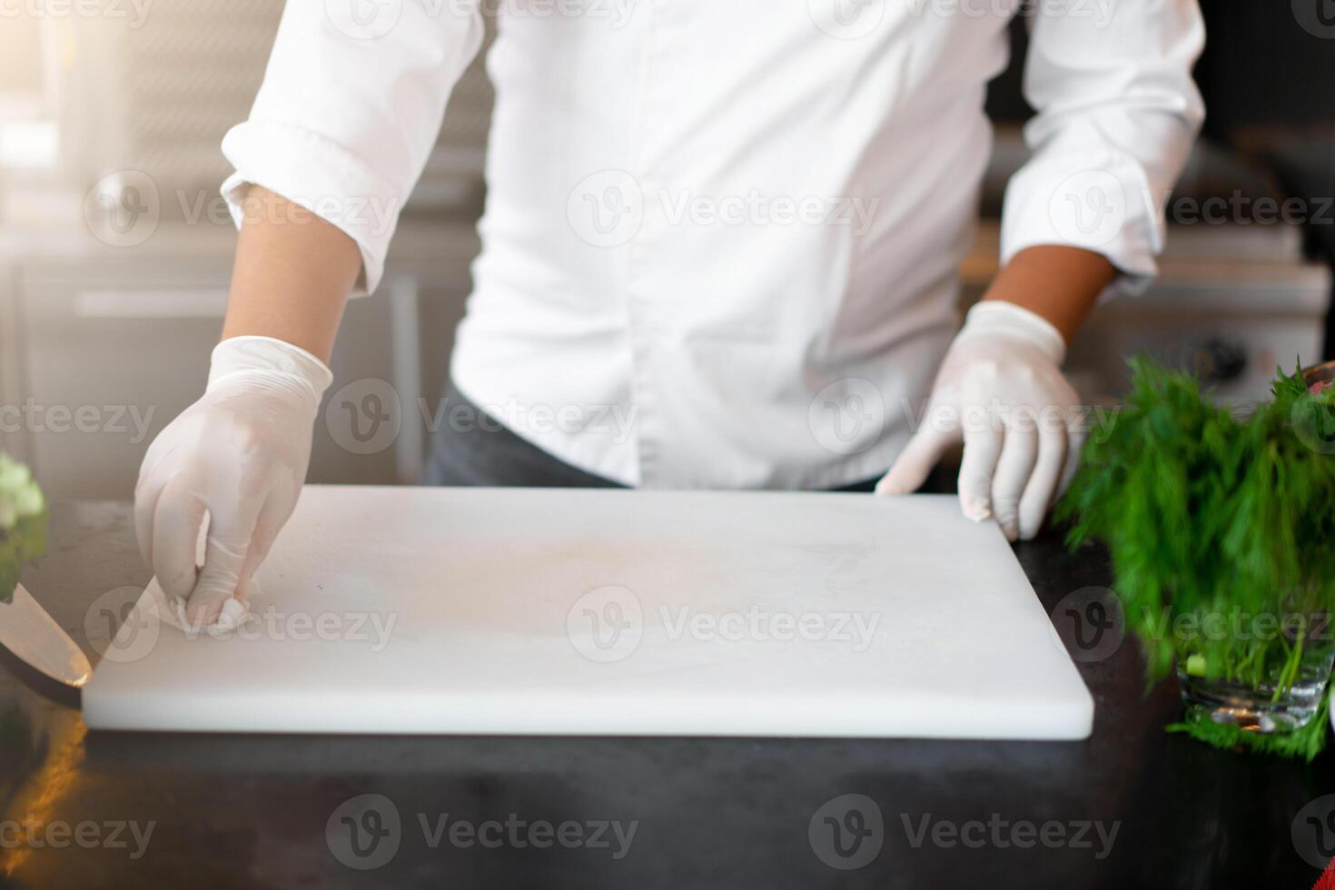 irreconocible joven africano cocinero en pie en profesional cocina en restaurante preparando un comida foto