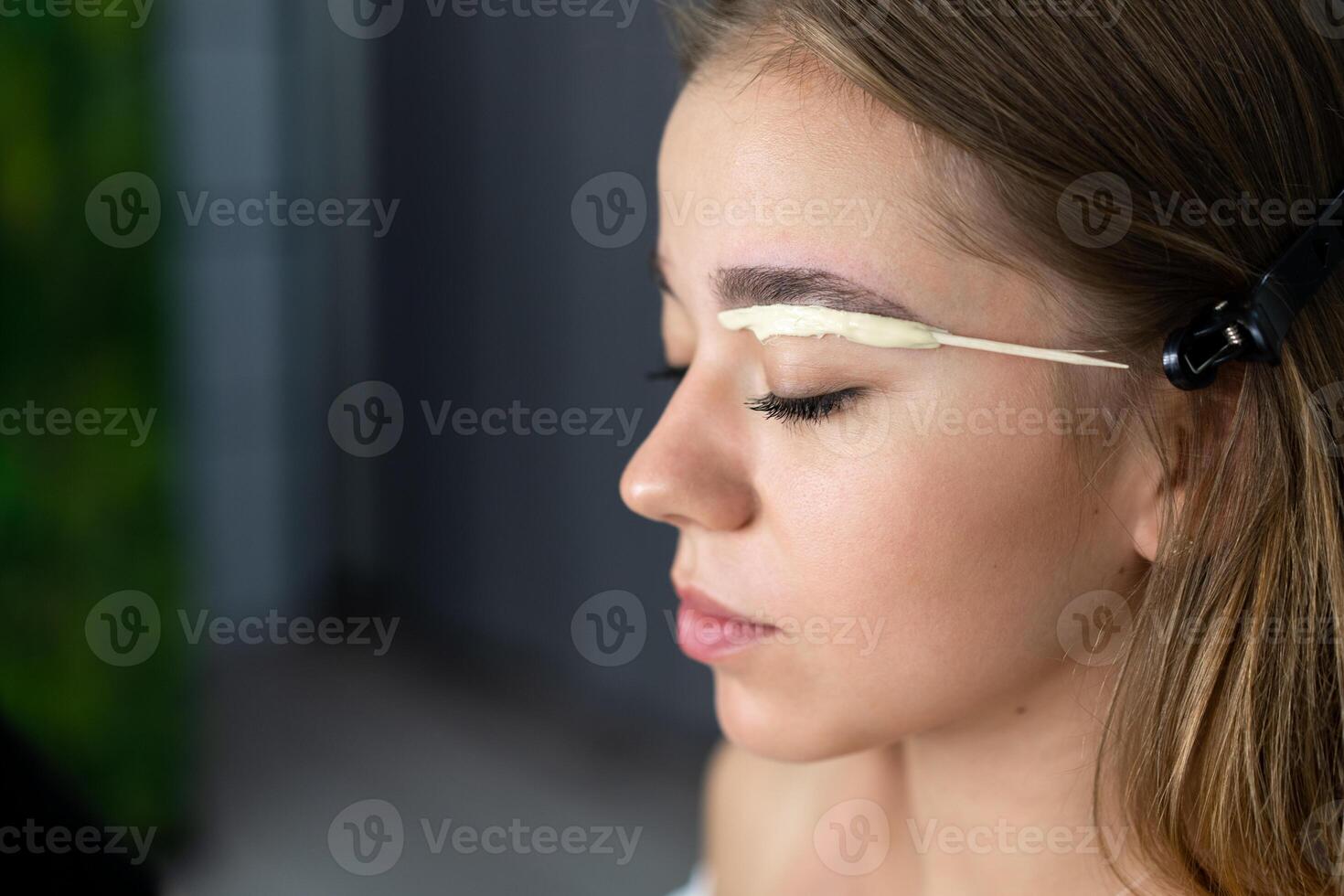 Young beautician caucasian girl holds model eyebrow correction photo