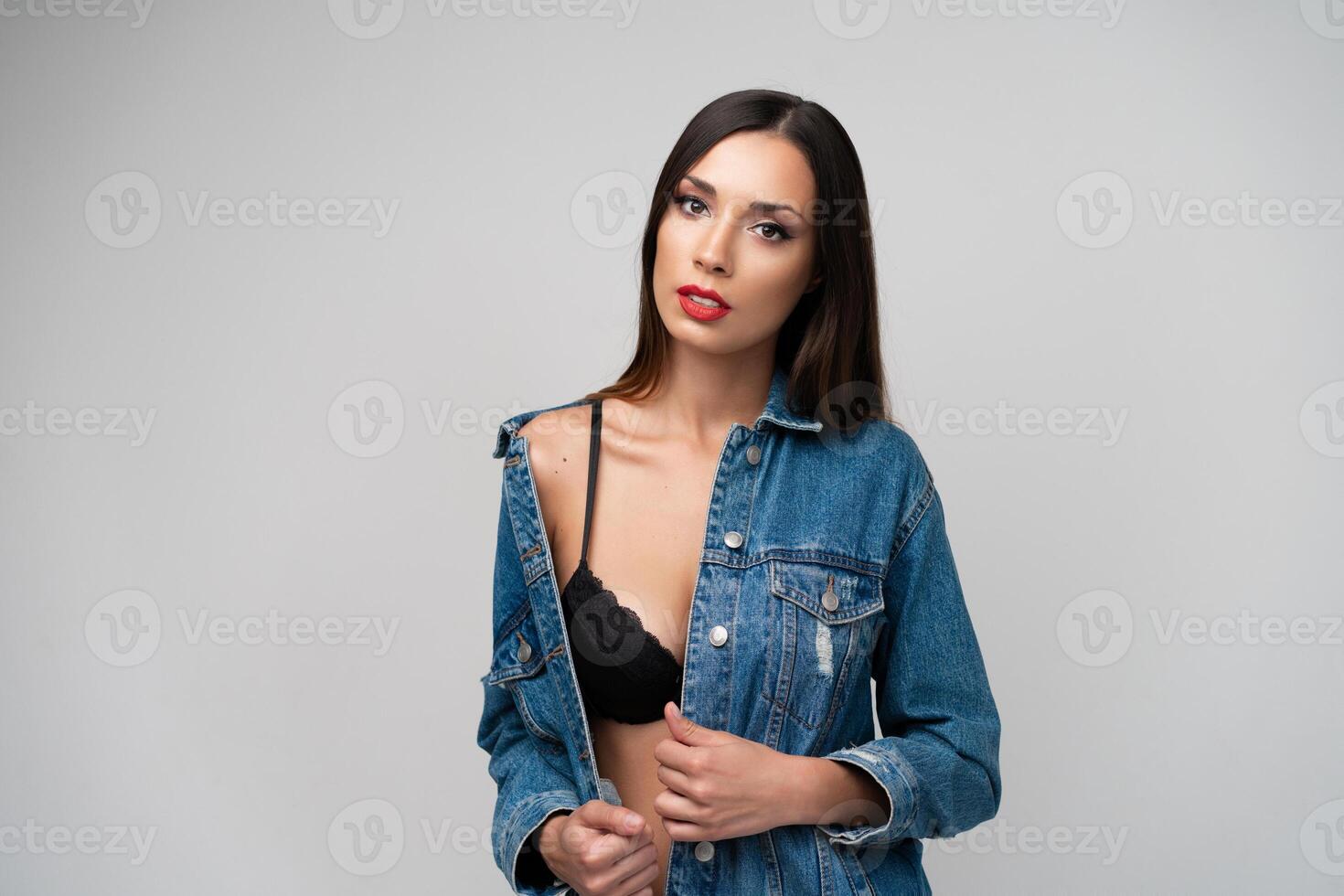 Beautiful caucasian girl in a denim jacket posing in the studio on a white background. photo