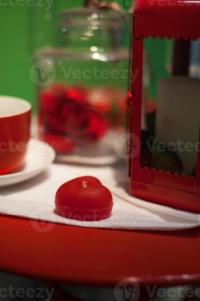 red heart candle on the table photo