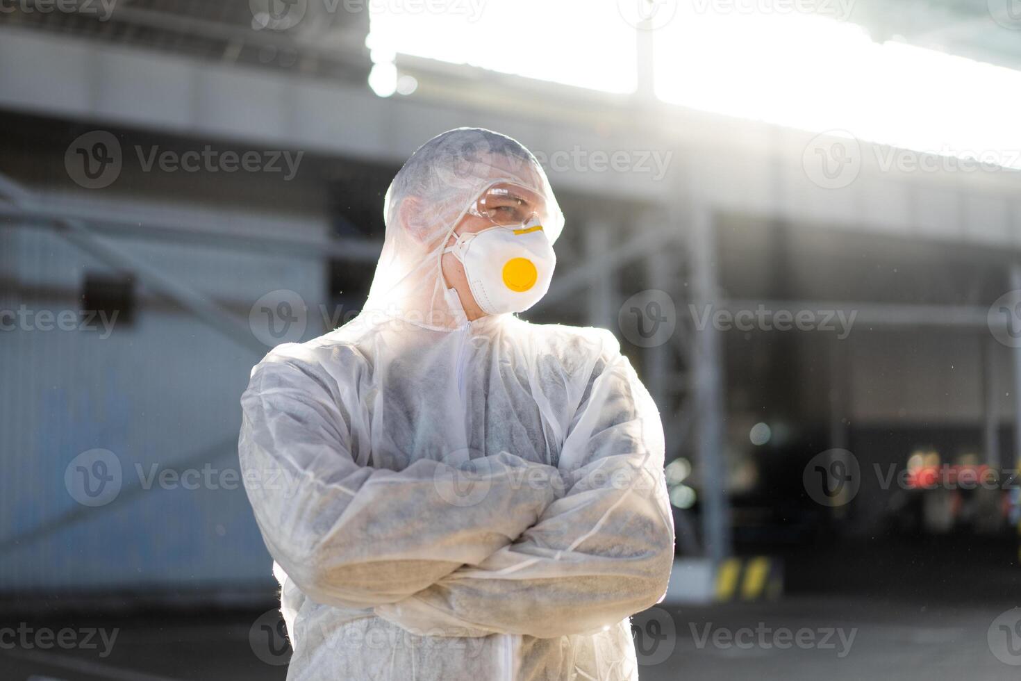 COVID-19 coronavirus doctor standing hospital parking dressed white protective overalls hazmat suit. photo