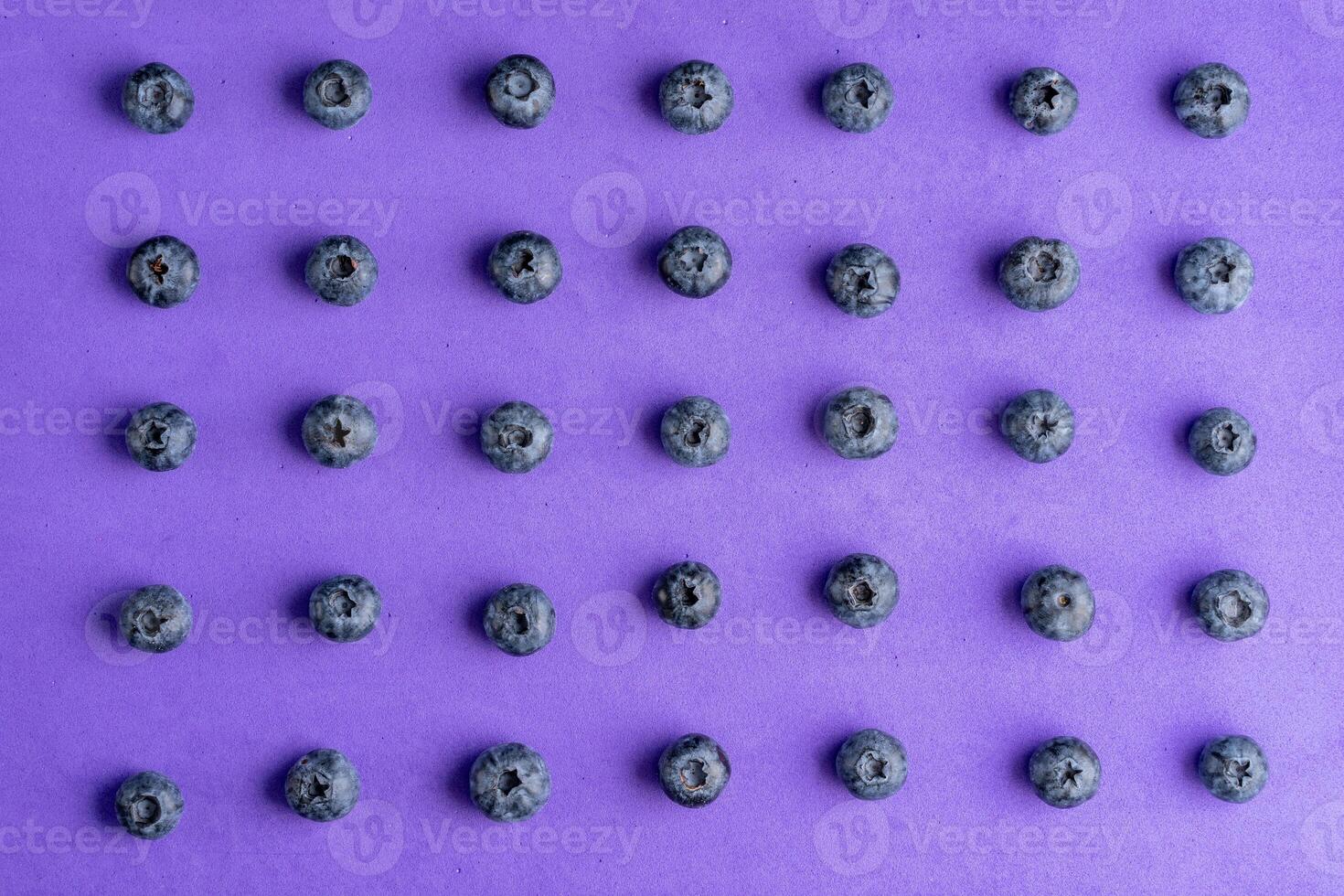 Colorful fruit pattern of blueberries on purple background. Top view. photo