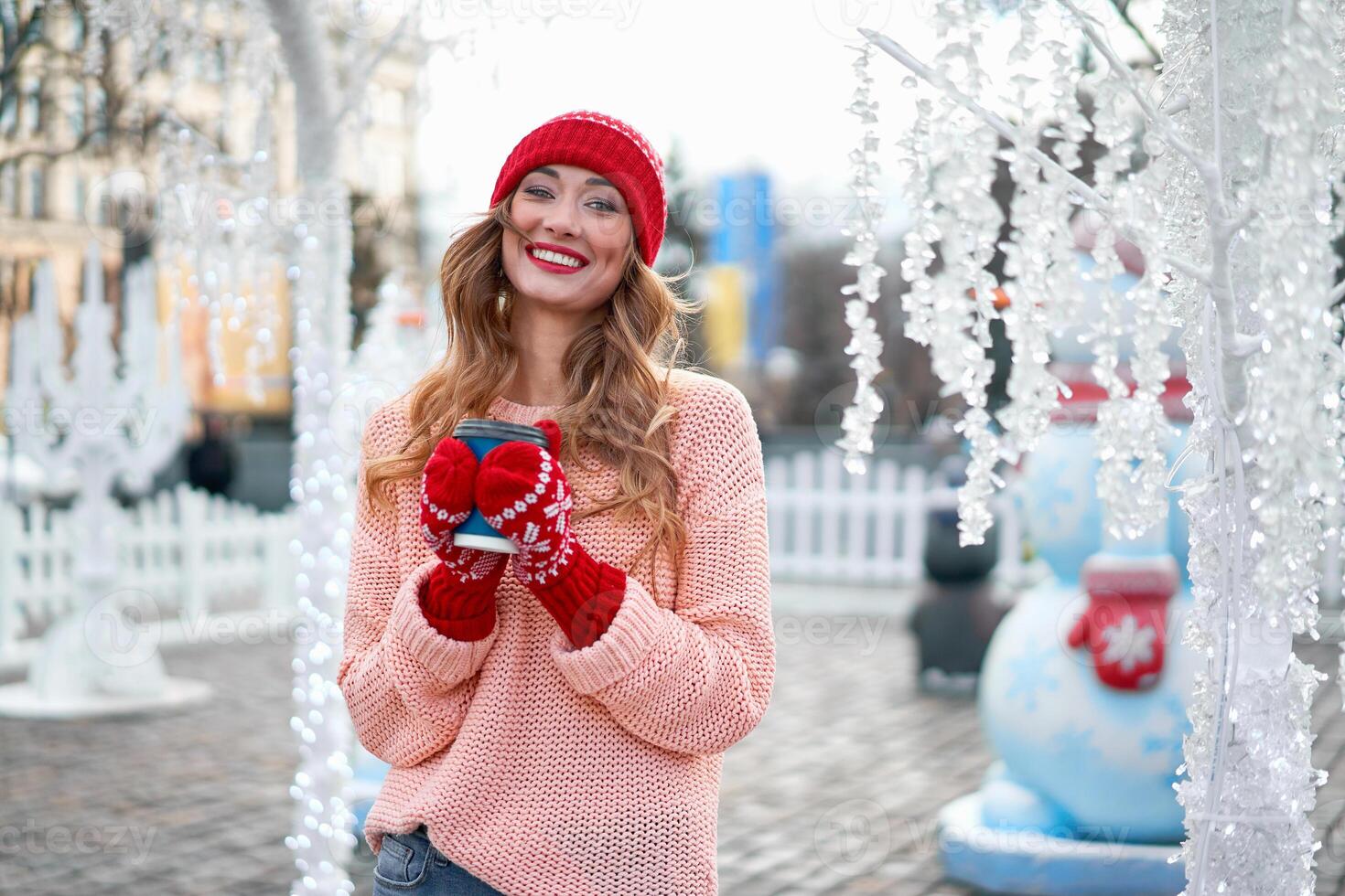 Beautiful lovely middle-aged girl with curly hair warm winter sweater stands background Town Square. photo