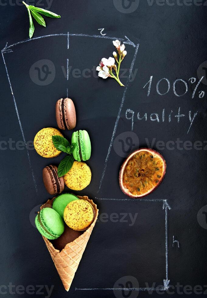 Chalkboard with a drawing of a waffle cone filled with macarons photo