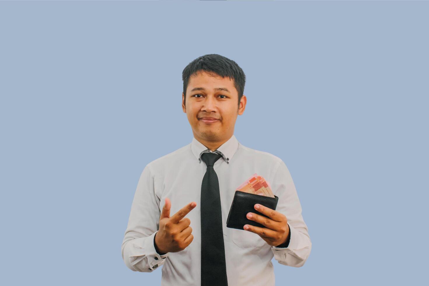 Adult Asian man smiling confident while pointing to wallet full of money that he hold photo