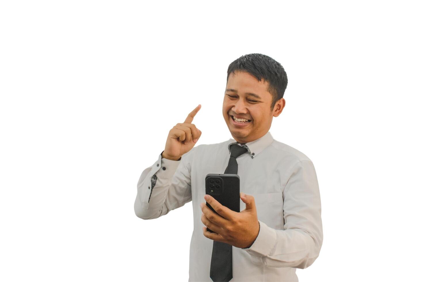 Adult Asian man smiling and pointing one hand up while holding mobile phone photo