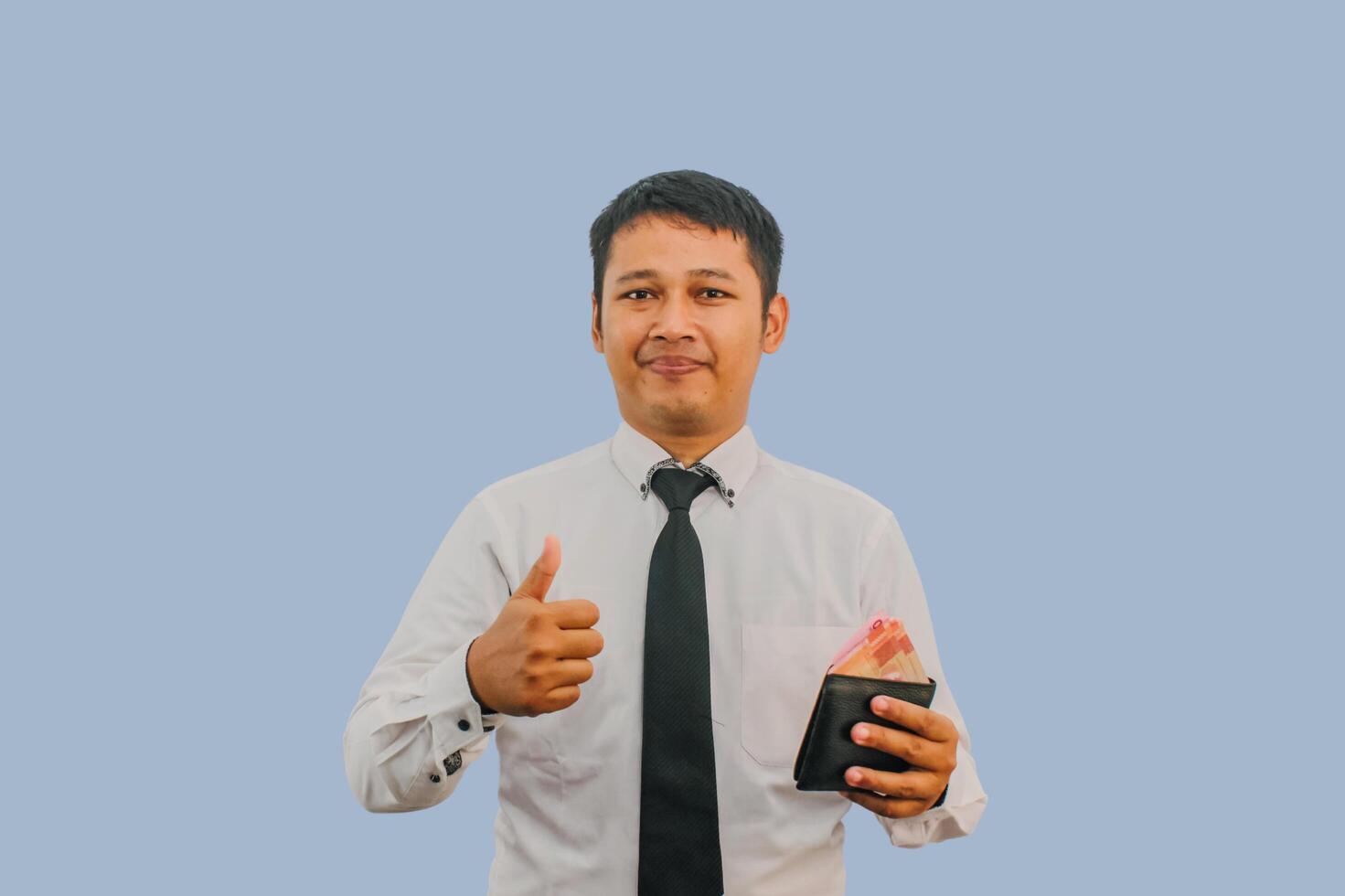 Adult Asian man smiling while holding wallet with money and give thumb finger sign photo