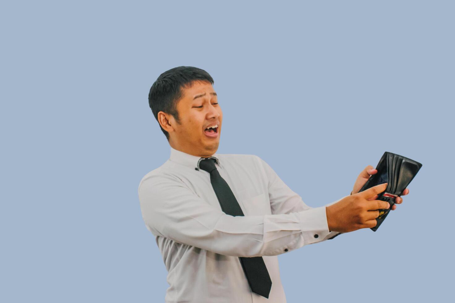 Adult Asian man showing shocked expression when looking to his empty wallet photo