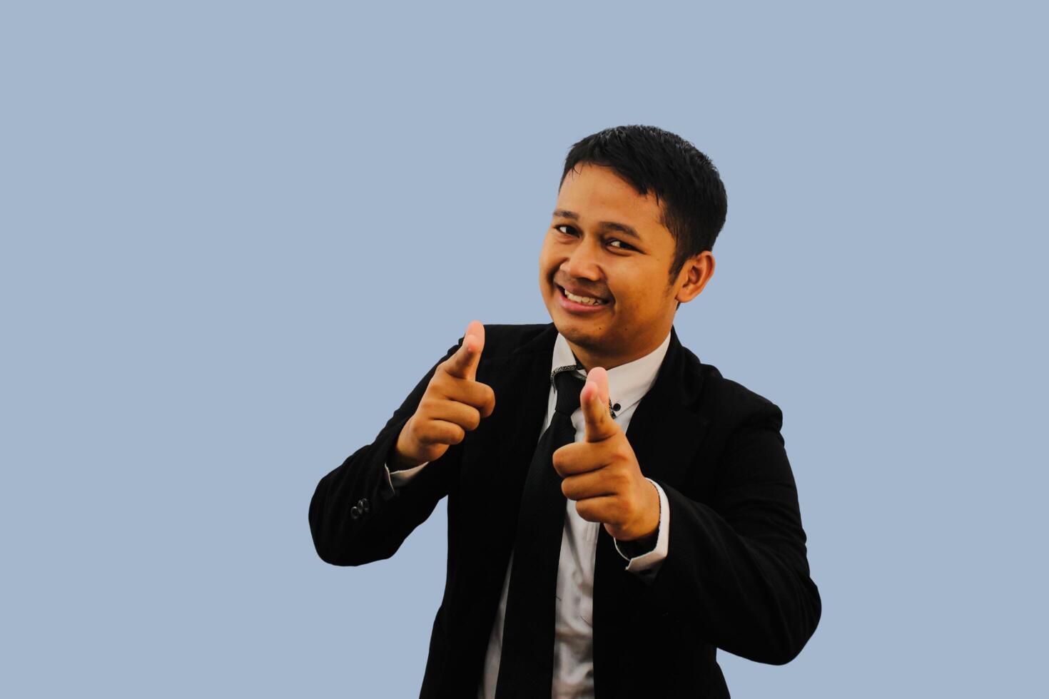 Adult Asian man smiling happy while pointing forward photo